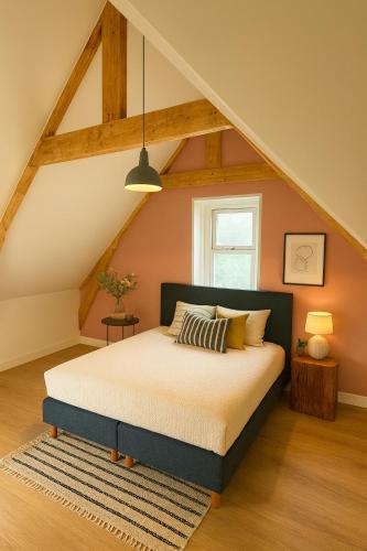 a bedroom with a bed in an attic at Groepsverblijf Villa d'Uylenburgh in Hommerts
