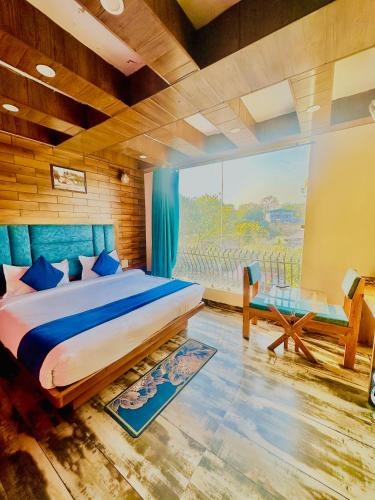 a bedroom with a large bed and a large window at Hotel Royal Orbit By Arony Hospitality Dehradun in Dehradun