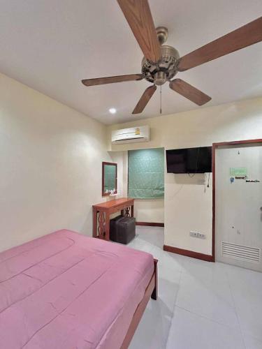 a bedroom with a pink bed and a ceiling fan at Khan House Patong in Patong Beach