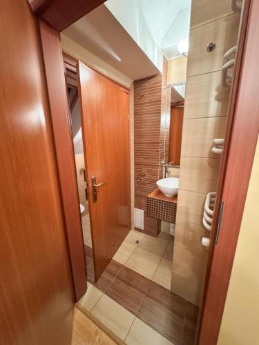 a bathroom with a wooden door and a sink at Terra Siciliana in Łęczyca