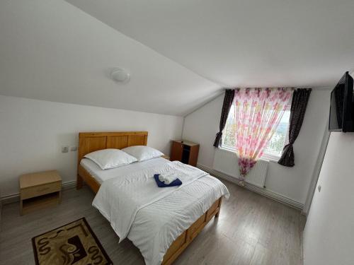 a bedroom with a bed and a large window at Casa Dia Belis in Beliş