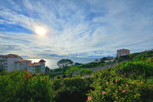 a view of the ocean from a hill with buildings at Ocean Breeze in Caniço