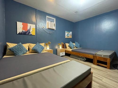 a room with two beds and a couch in it at Balai Evelyn Homestay in Coron