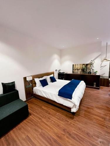 a bedroom with a large bed and a couch at Hulara Meadows in Lucknow