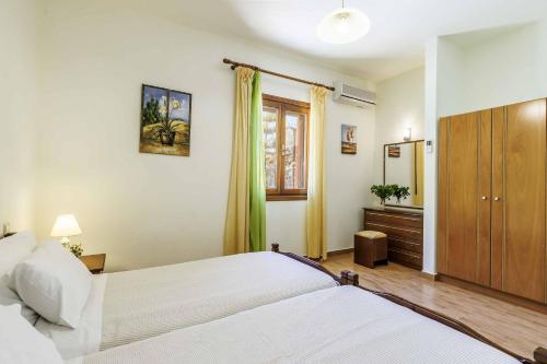 a bedroom with two beds and a dresser and a mirror at Villa Terracotta in Alikias