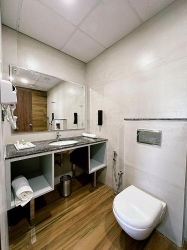 a bathroom with a toilet and a sink at Hulara Meadows in Lucknow