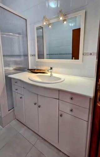 a white bathroom with a sink and a mirror at Casa Lu in Salir de Porto