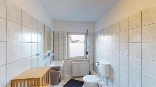 a bathroom with a toilet and a window at Hotel Landhaus in Eschweiler