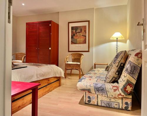 a bedroom with a bed and a couch and a chair at Les Ruisseaux in Gedinne
