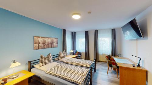a hotel room with a bed and a desk and a desk at Hotel Landhaus in Eschweiler