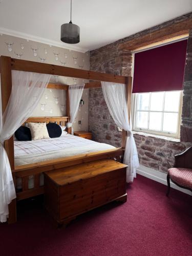 ein Schlafzimmer mit einem Bett und einer Ziegelwand in der Unterkunft Ecclefechan Hotel in Ecclefechan