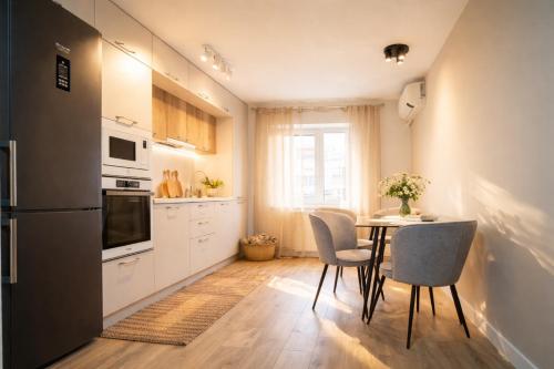 a kitchen with a table and chairs and a refrigerator at FF Residence in Deva