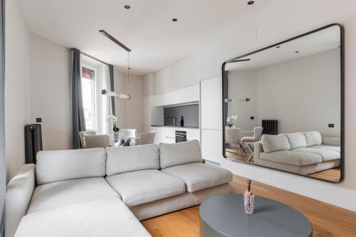a living room with a white couch and a large mirror at Luxury Calzolerie in Bologna