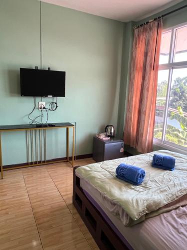 a bedroom with a bed with two blue pillows on it at ใบไม้ in Ko Si Chang