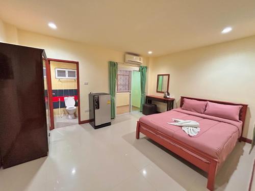 a bedroom with a pink bed and a bathroom at Khan House Patong in Patong Beach