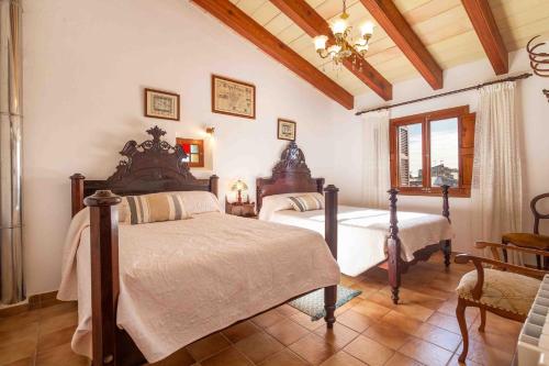 a bedroom with two beds and a ceiling at Es Pujols in Campanet