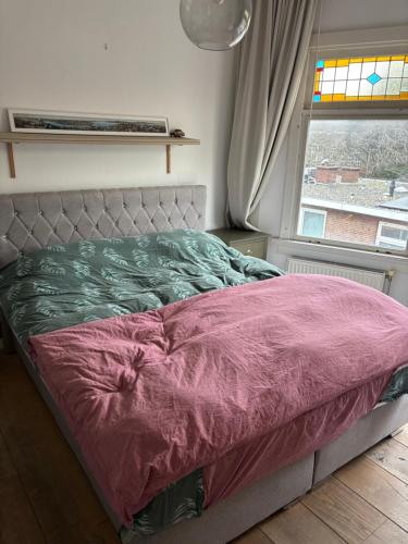 a bed sitting in a bedroom with a window at Nice apartment next to the beach in Scheveningen