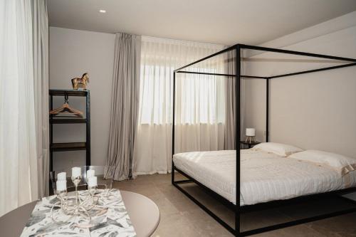 a bedroom with a black canopy bed and a table at LVguesthouse in Priocca