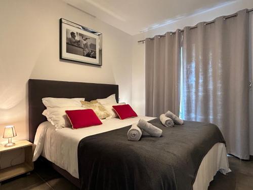 a bedroom with a large bed with red pillows at Residence Capriona in Porto Pollo