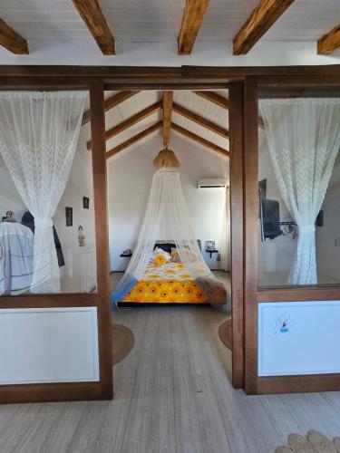 a bedroom with a bed in a room with windows at Casa de Vacanta Nufarul Crisan in Tulcea