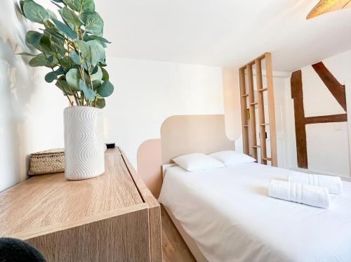 a bedroom with a bed and a vase with a plant at Chic Home - Turckheim in Turckheim