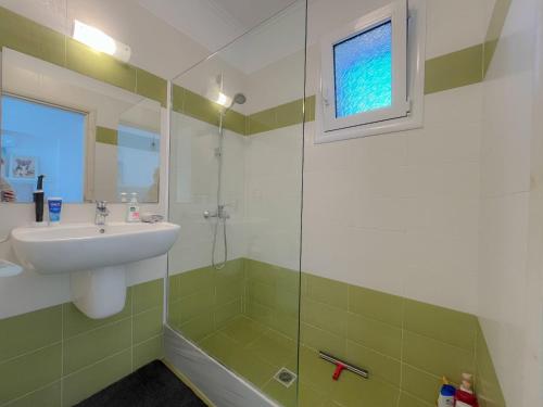 a bathroom with a sink and a shower at Villa M&M met eigen zwembad in Kalamaki