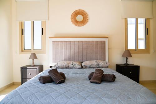 a bedroom with a bed with two brown pillows on it at Sorelia Latchi Villas 2 - Merope Irena in Polis Chrysochous