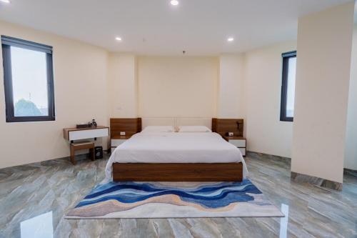 a bedroom with a large bed and a desk at 合意酒店 in Việt Yên
