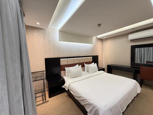 a hotel room with a bed and a desk at اكارم - إشبيلية - Akarem - iishbilia - اقتصادي in Riyadh