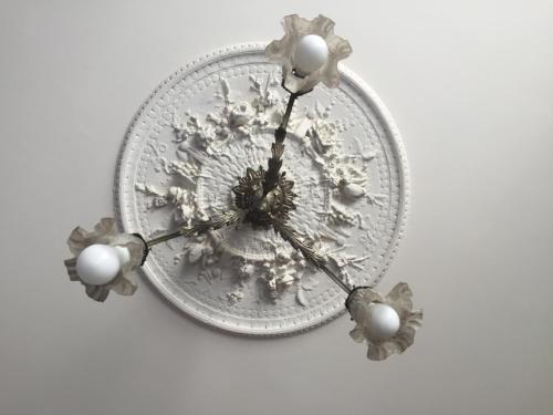 a glass clock with flowers on a white wall at Au Petit Bonheur in Talence