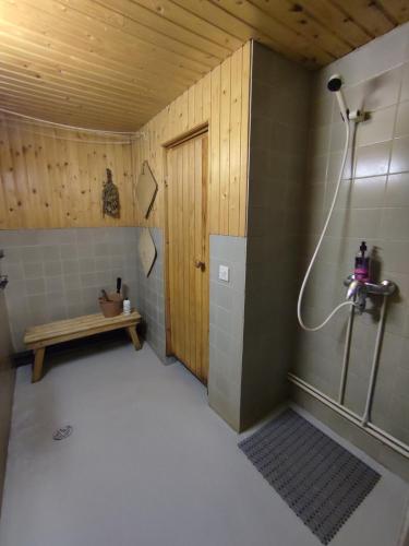 a bathroom with a shower and a bench in it at Blue House Nature Retreat with Private Garden in Sastamala