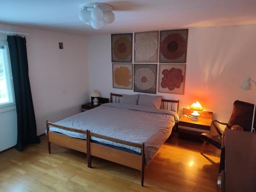 a bedroom with a bed and a chair and a window at Blue House Nature Retreat with Private Garden in Sastamala