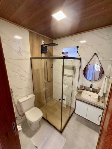 a bathroom with a shower and a toilet and a sink at Chalés Bermond- Rota da Ferradura in Guarapari