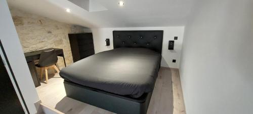 a bedroom with a bed in the corner of a room at Gite Rive Charente La Cabane in Bords