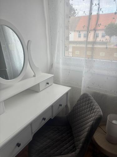 a white bathroom with a mirror and a chair at Apartman Loni , Belišće in Belišće