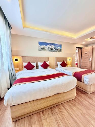 ein Schlafzimmer mit zwei Betten und roten Kissen in der Unterkunft Hotel Aerocity in Kathmandu
