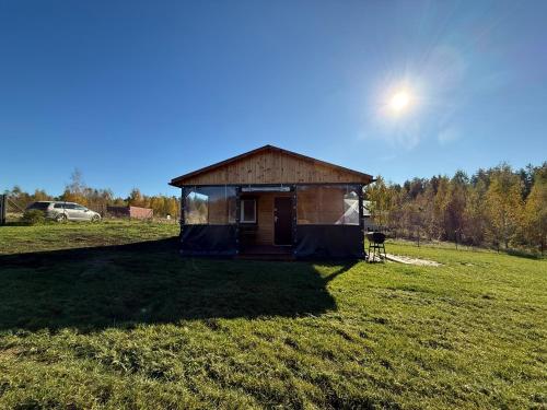 a small building in the middle of a field at Domki letniskowe Ruś in Ruś