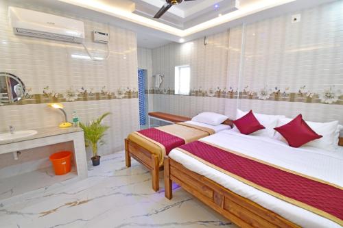 a bedroom with two beds and a bathroom with a sink at SRK Residency in Pūrnānkuppam