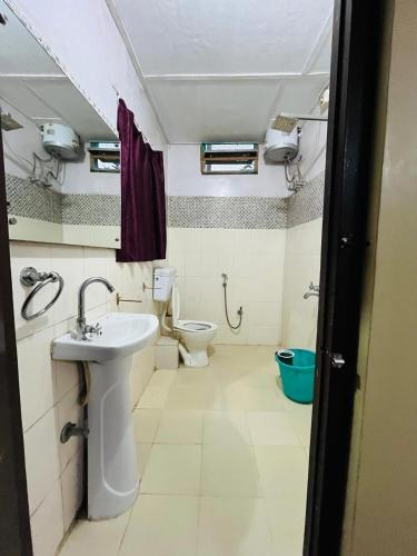 a bathroom with a sink and a toilet at Executive Guest House in Guwahati