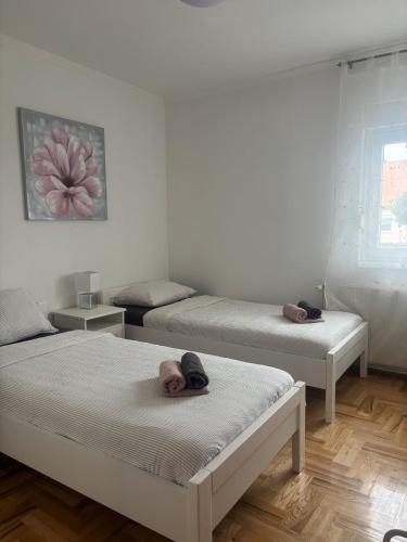 a room with three beds with towels on them at Apartman Loni , Belišće in Belišće