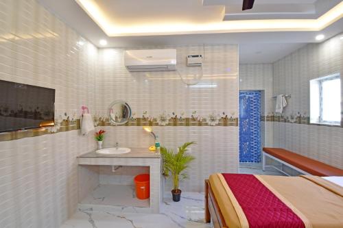 a bathroom with a bed and a sink in a room at SRK Residency in Pūrnānkuppam