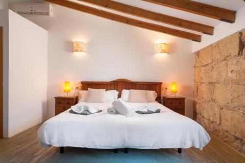 a bedroom with a large white bed with two lamps at Villa Moscari in Moscari