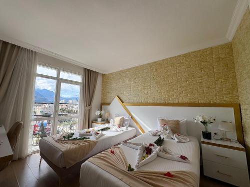 zwei Betten in einem Hotelzimmer mit Blumen darauf in der Unterkunft Far Life Hotel in Antalya