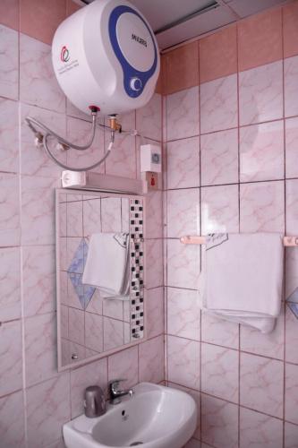 a bathroom with a sink and a blow dryer at HOTEL DE LA VALLEE NEW in Yaoundé