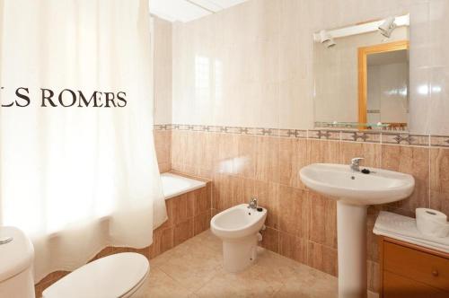 a bathroom with a sink and a toilet and a mirror at Apartamentos Els Romers Benicarló-Peñíscola in Peniscola