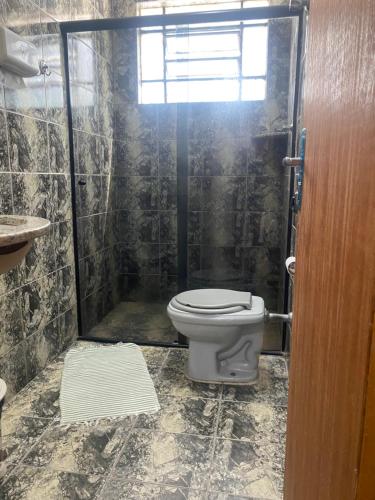 a bathroom with a toilet and a shower at Pousada da Vânia in Vespasiano