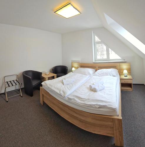 a bedroom with a bed with white sheets and a window at MOTOREST-PENSION U HRACHŮ,s.r.o. in Klatovy