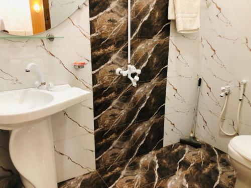 a bathroom with a sink and a toilet at Holiday One Hotel & Suites - Gulshan-3 in Karachi