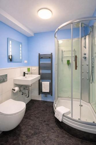 a bathroom with a shower and a toilet and a sink at Silvio-Gesell-Tagungsstätte in Wuppertal