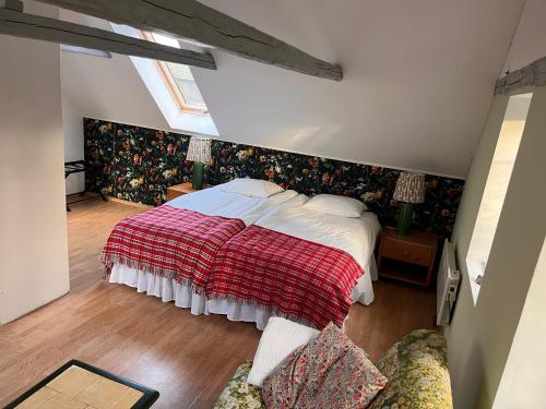 a bedroom with a large bed with a red blanket at Højriisgaard B & B in Nørreby